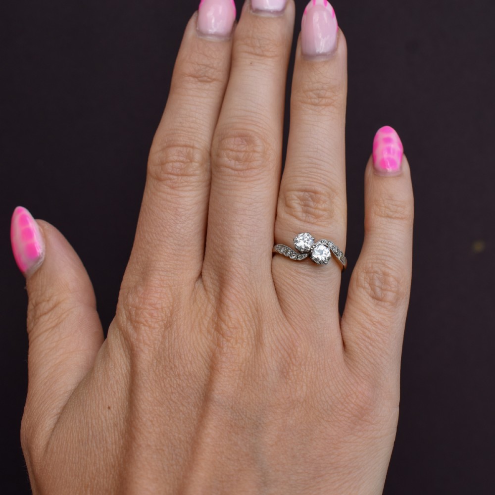 An antique diamond Toi et Moi ring featuring two diamonds set in a platinum crossover mount on an eighteen carat gold band. View X