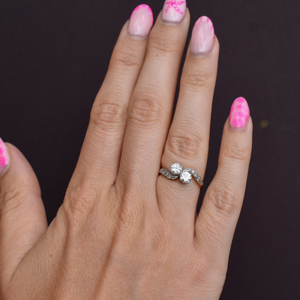 An antique diamond Toi et Moi ring featuring two diamonds set in a platinum crossover mount on an eighteen carat gold band. View XI