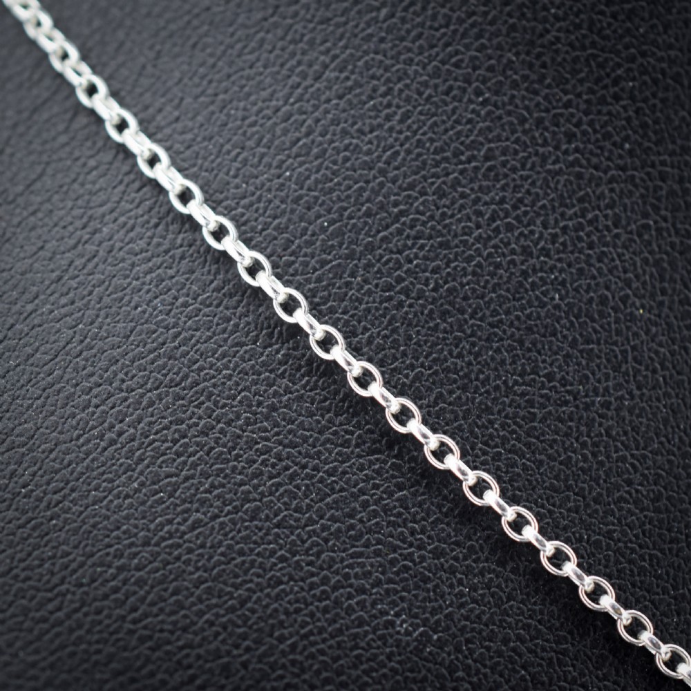 An antique silver necklace featuring a heart-shaped purple paste central stone surrounded by clear paste stones and topped with a bow motif. View IV