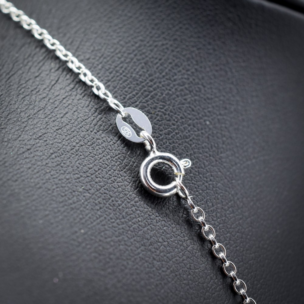 An antique silver necklace featuring a heart-shaped purple paste central stone surrounded by clear paste stones and topped with a bow motif. View V