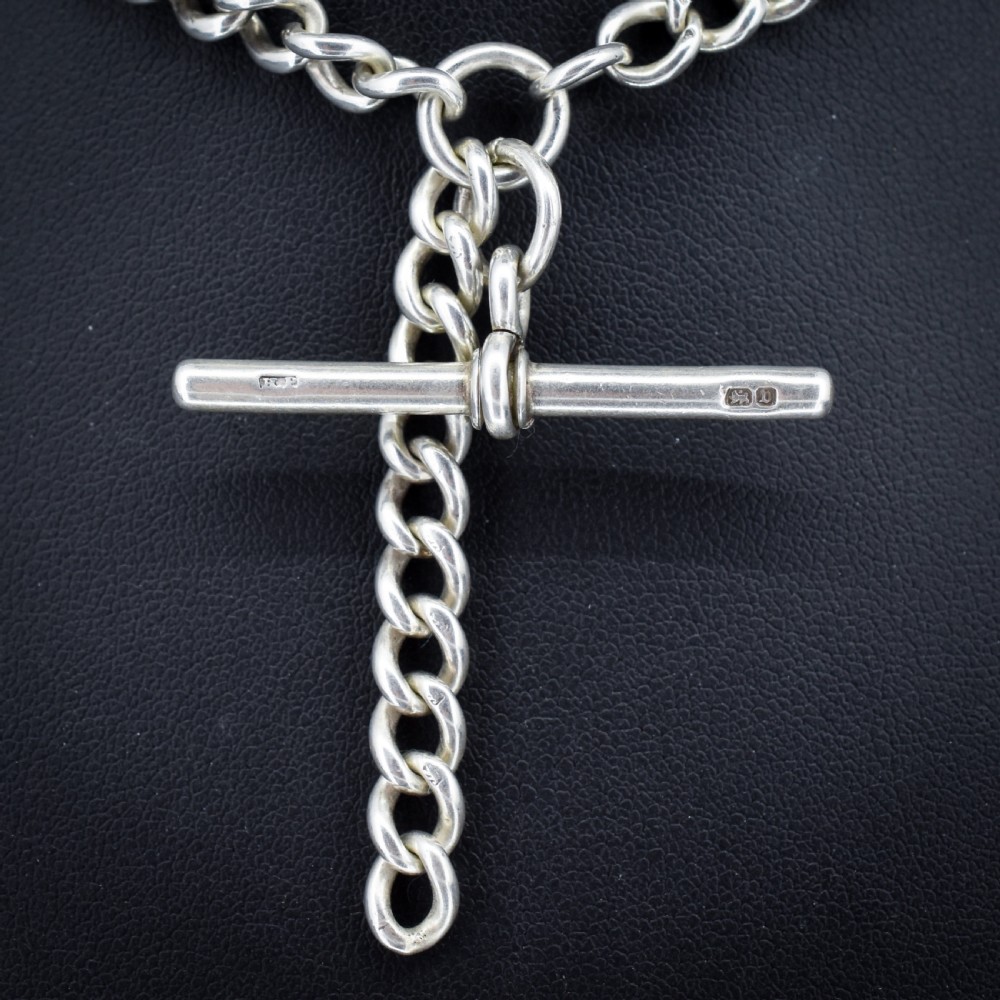 A sterling silver curb link Albert watch chain necklace featuring a central T-bar attachment and swivel clasp on a black bust. View II