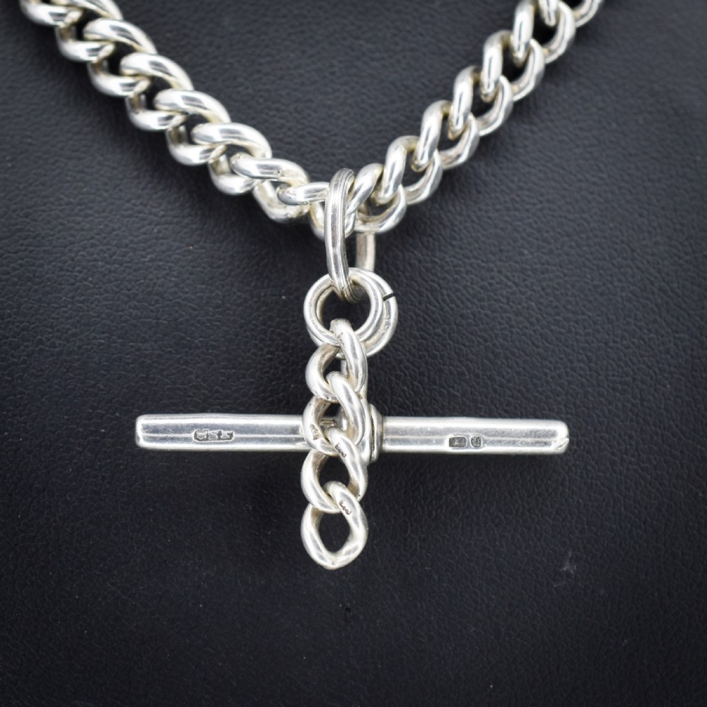 A sterling silver uniform curb link necklace with a T-bar pendant and dog clip clasp displayed on a black neck bust. View II