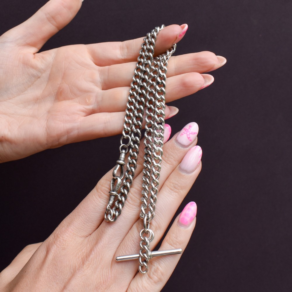 A sterling silver uniform curb link necklace with a T-bar pendant and dog clip clasp displayed on a black neck bust. View VII