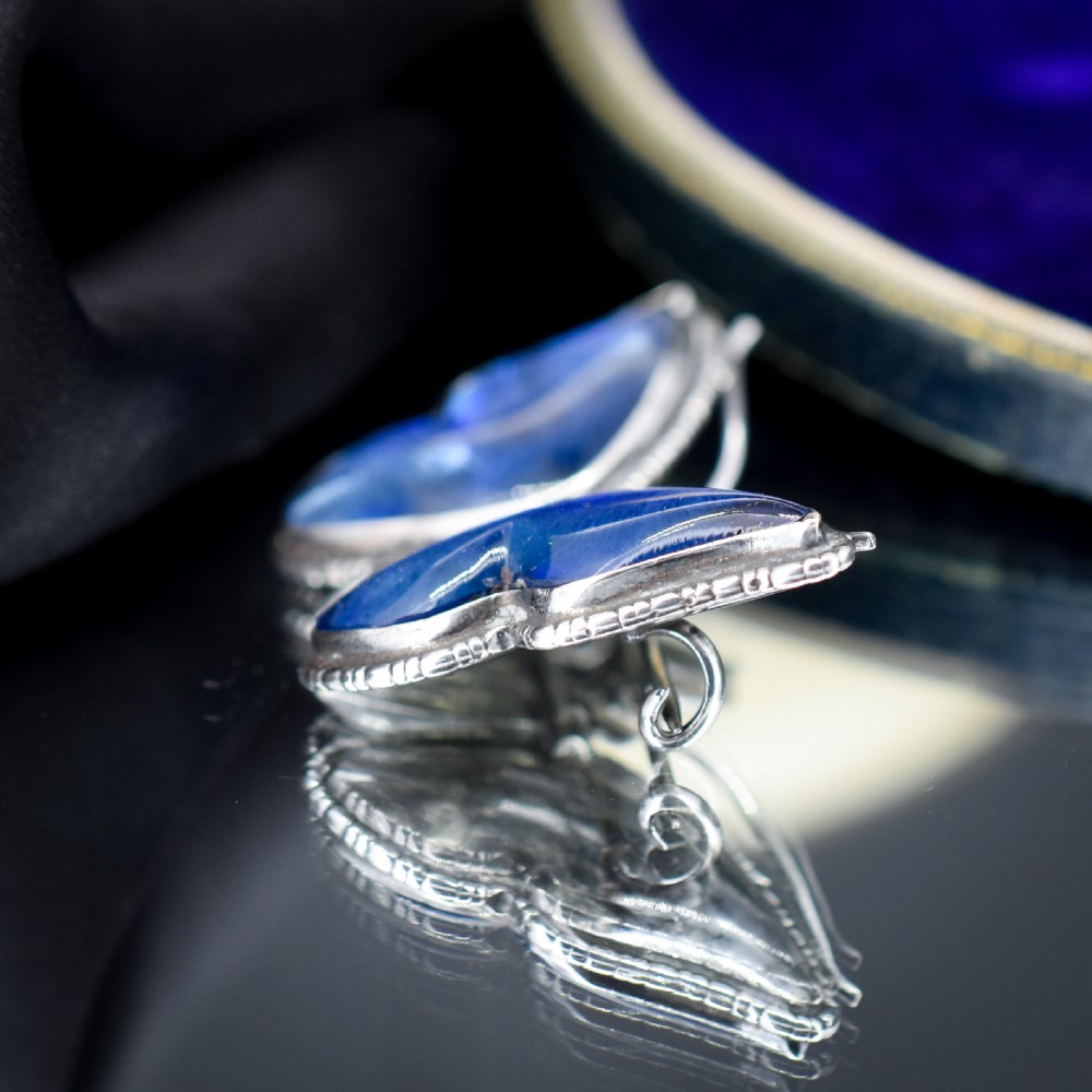 An Art Deco sterling silver butterfly brooch featuring vibrant iridescent blue butterfly wing panels beneath glass. View VI
