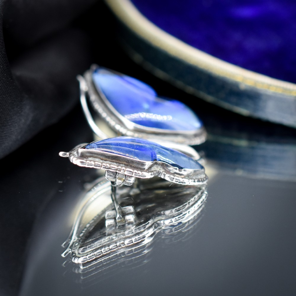 An Art Deco sterling silver butterfly brooch featuring vibrant iridescent blue butterfly wing panels beneath glass. View VII