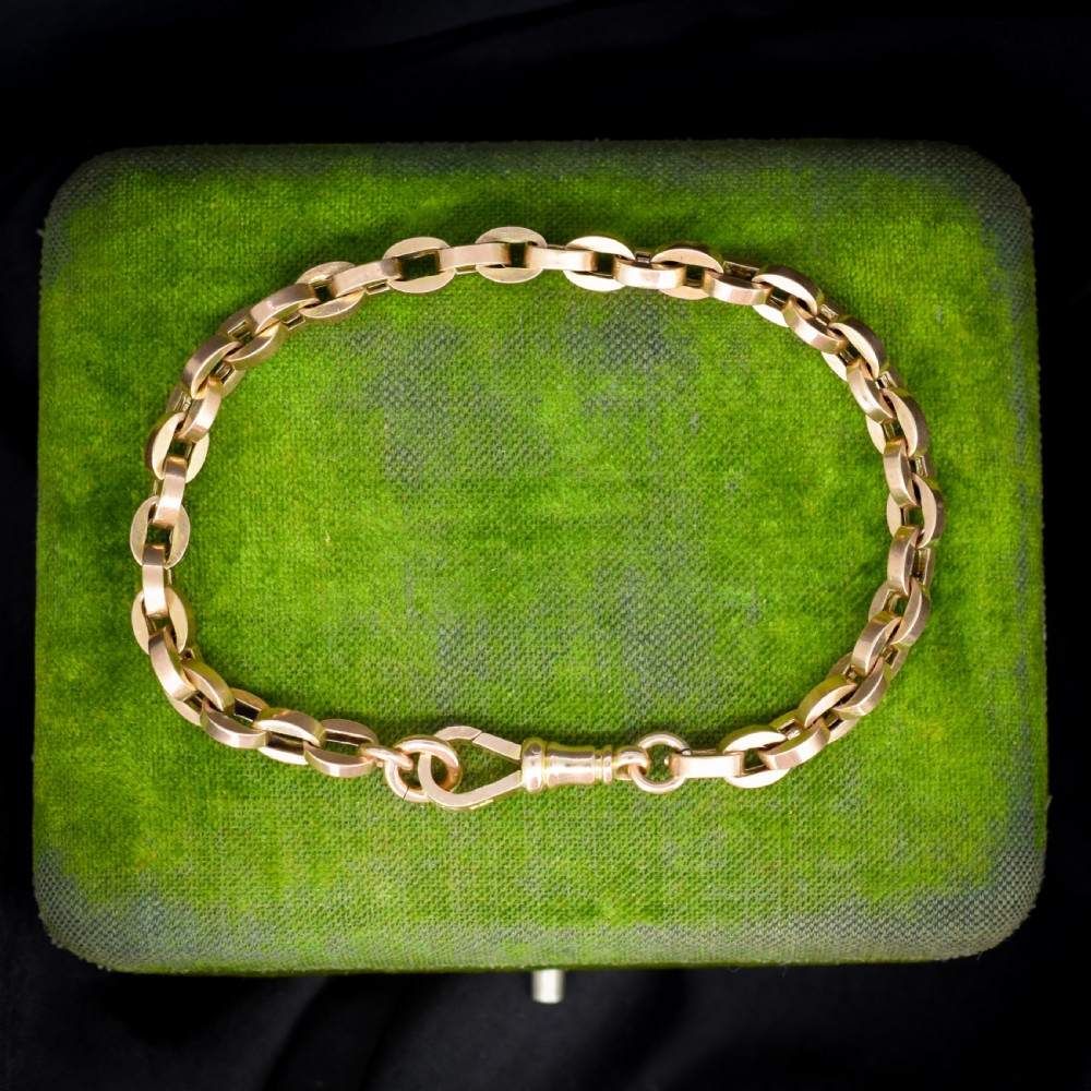 An antique 9ct yellow gold bracelet featuring uniform oval cable links secured with a swivel dog clip fastener.