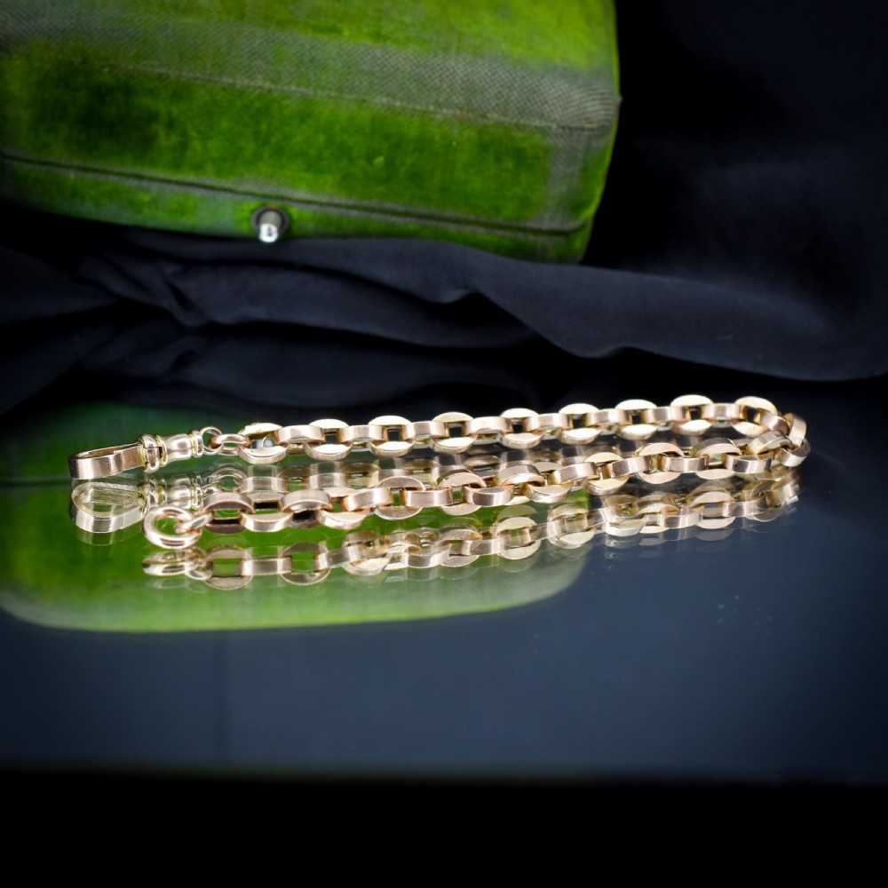 An antique 9ct yellow gold bracelet featuring uniform oval cable links secured with a swivel dog clip fastener. View V