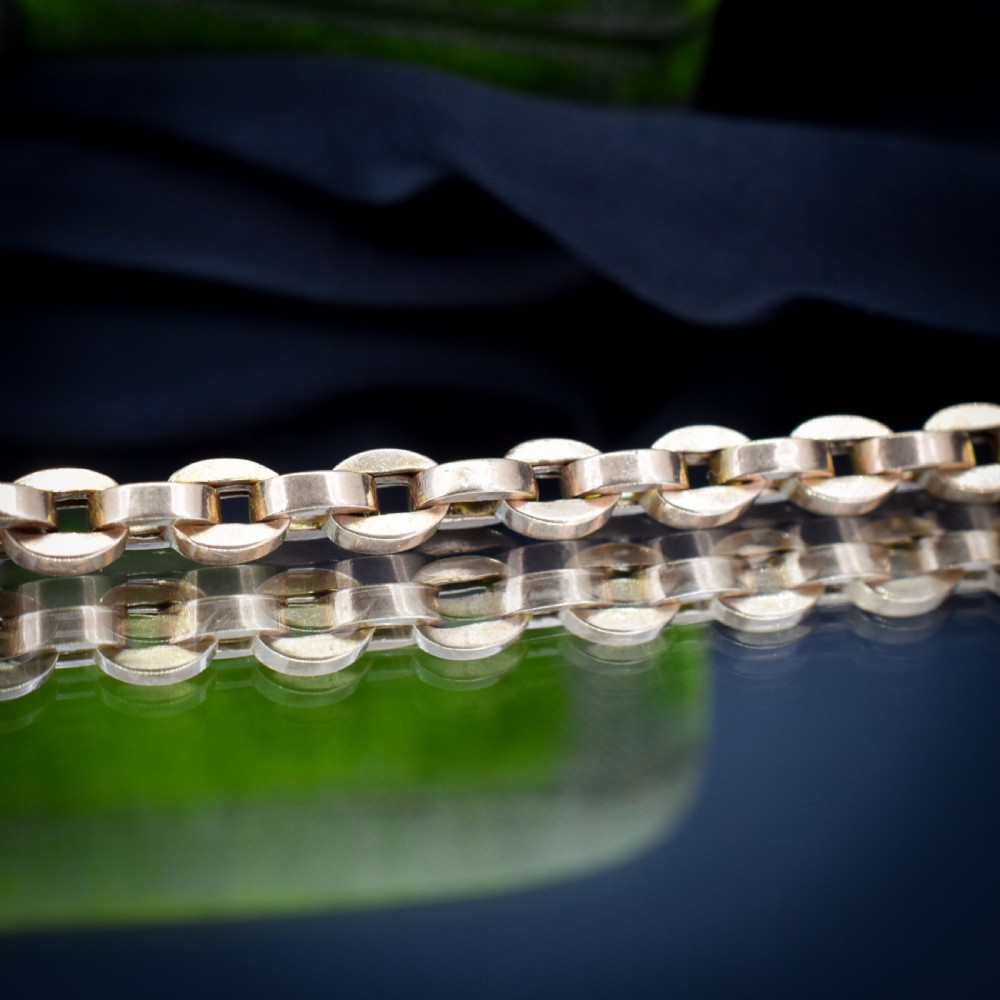 An antique 9ct yellow gold bracelet featuring uniform oval cable links secured with a swivel dog clip fastener. View VI