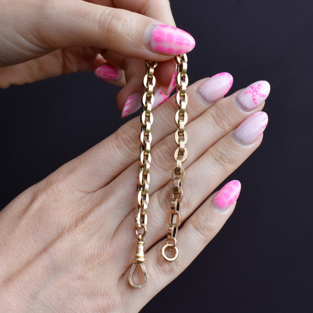 An antique 9ct yellow gold bracelet featuring uniform oval cable links secured with a swivel dog clip fastener. View VII