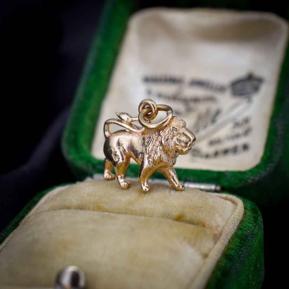 A small 9ct yellow gold charm sculpted in the shape of a standing lion with a textured mane. View III