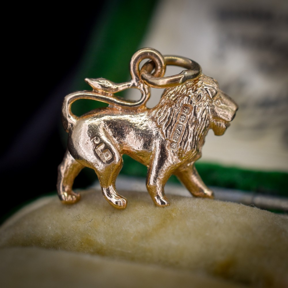 A small 9ct yellow gold charm sculpted in the shape of a standing lion with a textured mane. View V