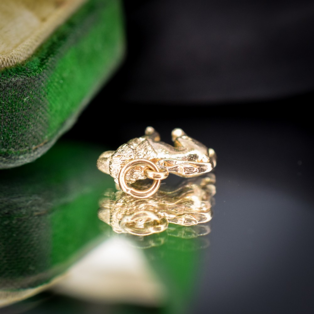 A small 9ct yellow gold charm sculpted in the shape of a standing lion with a textured mane. View VI