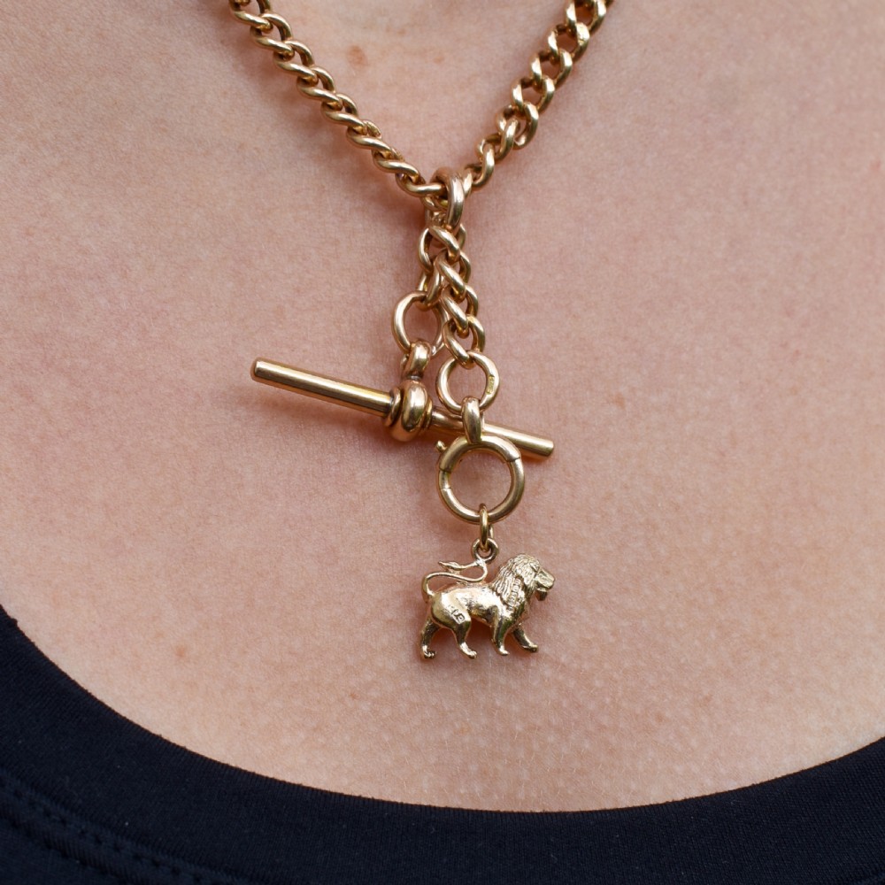 A small 9ct yellow gold charm sculpted in the shape of a standing lion with a textured mane. View VIII