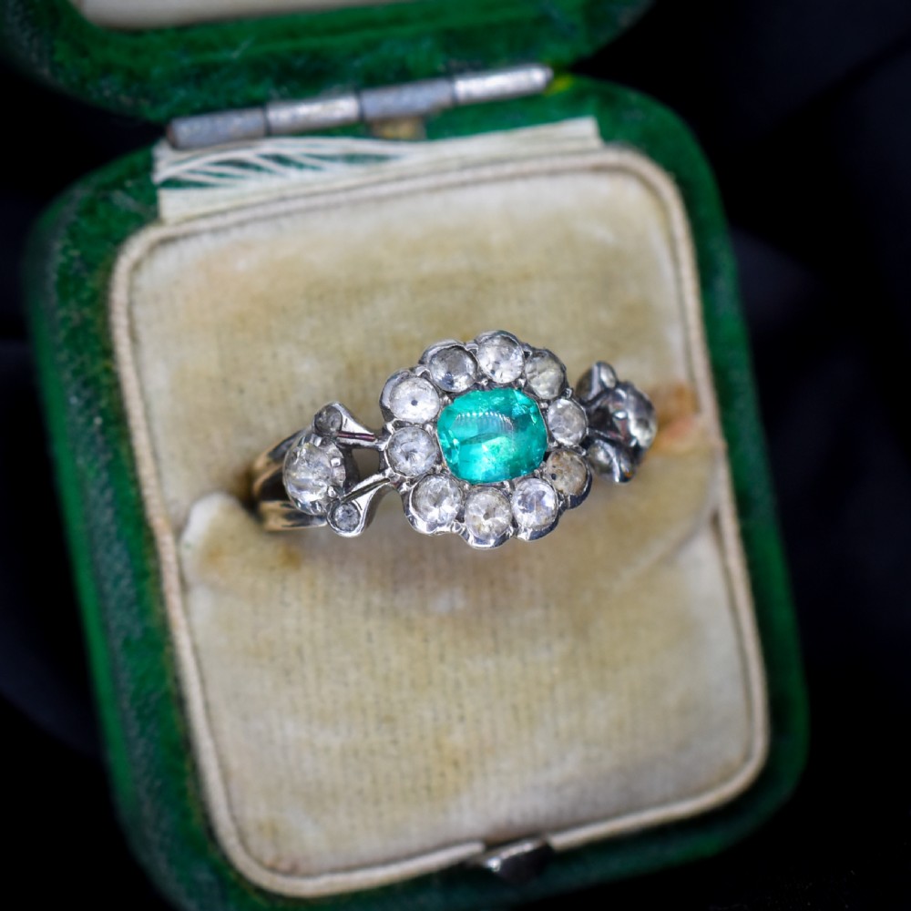 An antique Georgian cluster ring featuring a central cushion-cut green paste stone surrounded by clear paste stones set in silver and gold. View II