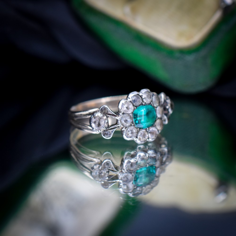 An antique Georgian cluster ring featuring a central cushion-cut green paste stone surrounded by clear paste stones set in silver and gold. View IV