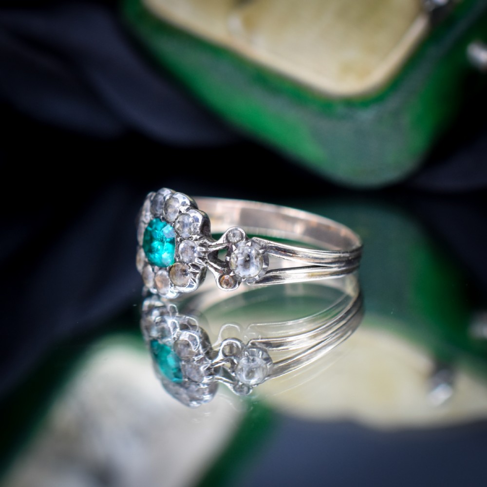 An antique Georgian cluster ring featuring a central cushion-cut green paste stone surrounded by clear paste stones set in silver and gold. View VI