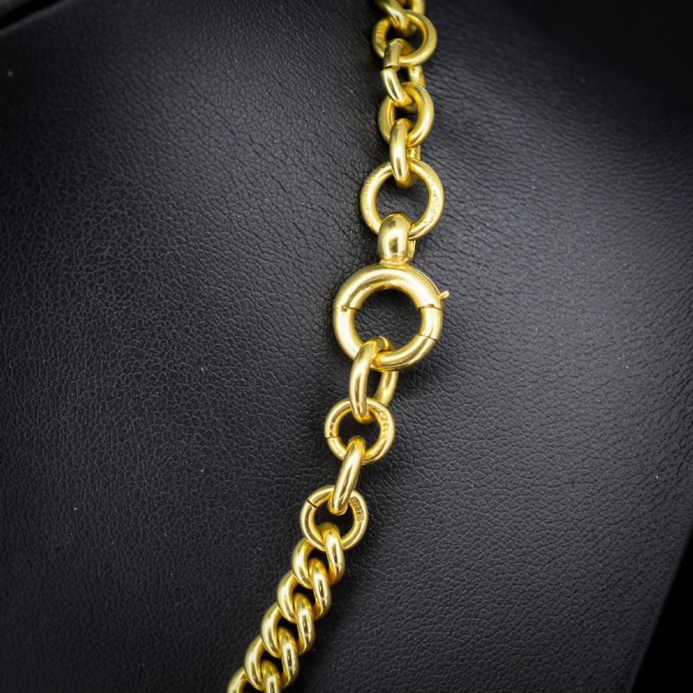 An 18ct yellow gold curb link Albert chain necklace featuring a central ring with a T-bar drop, displayed on a black jewellery bust. View IV