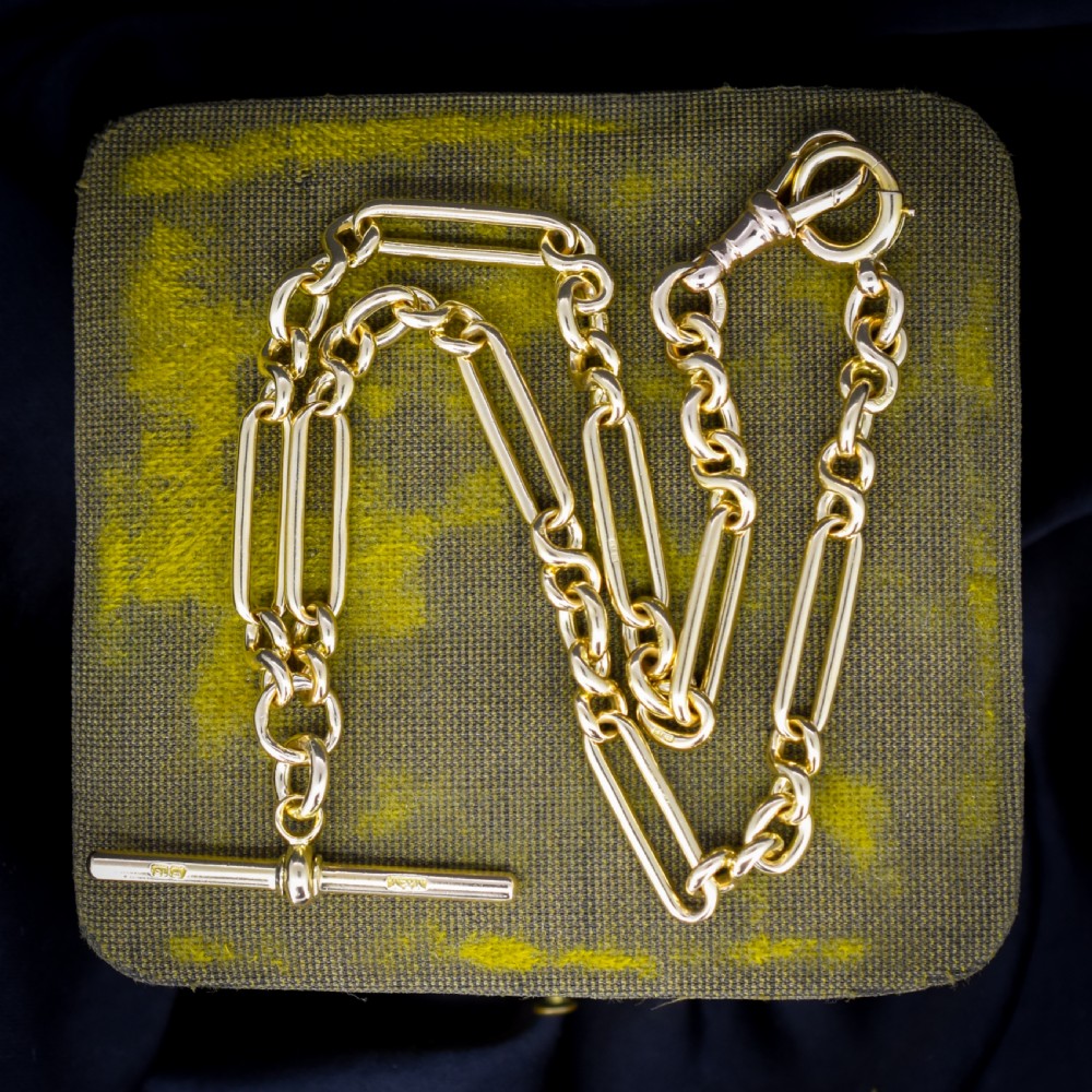 An antique 18ct yellow gold trombone link watch chain featuring an integrated T-bar and swivel clasp fastener.