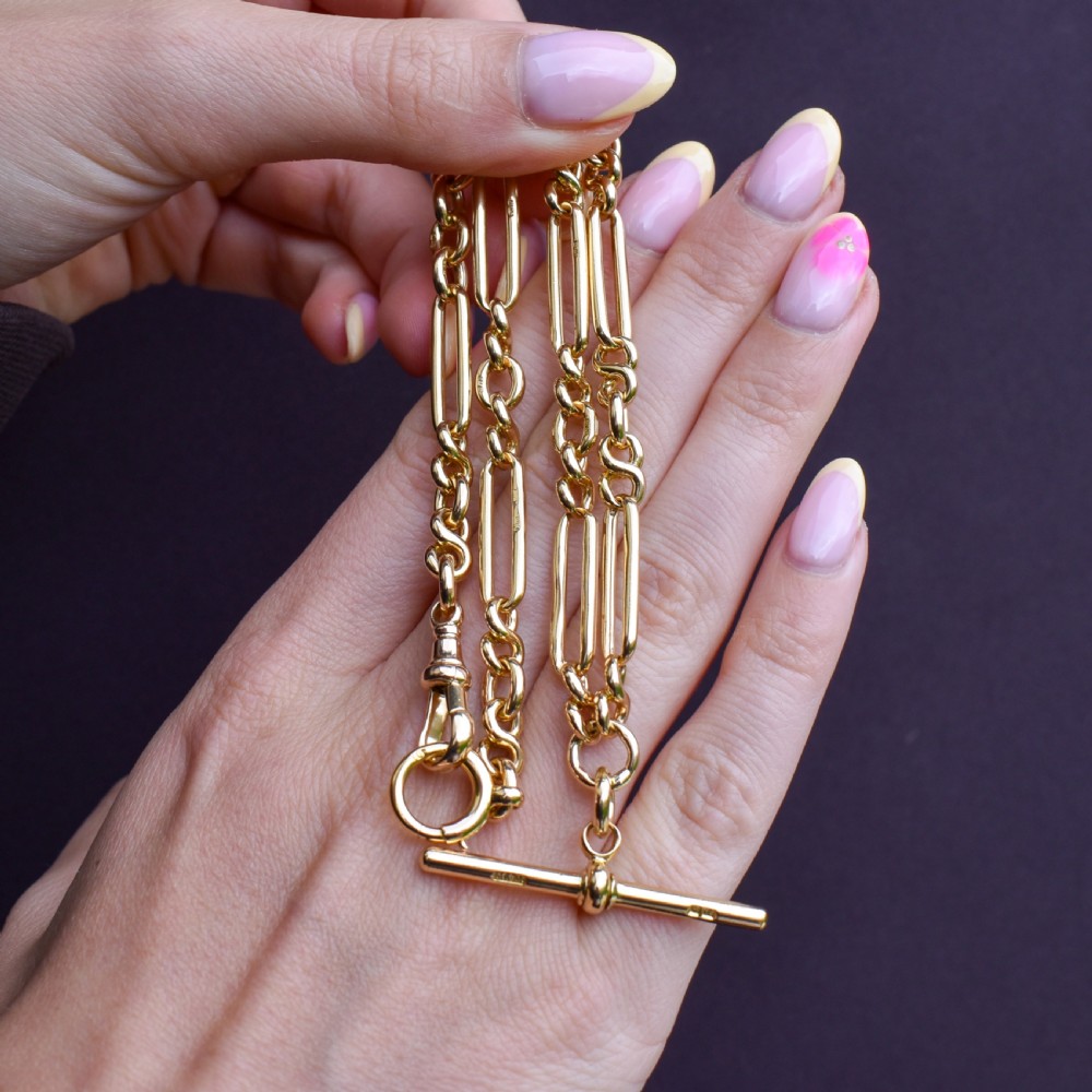 An antique 18ct yellow gold trombone link watch chain featuring an integrated T-bar and swivel clasp fastener. View IX