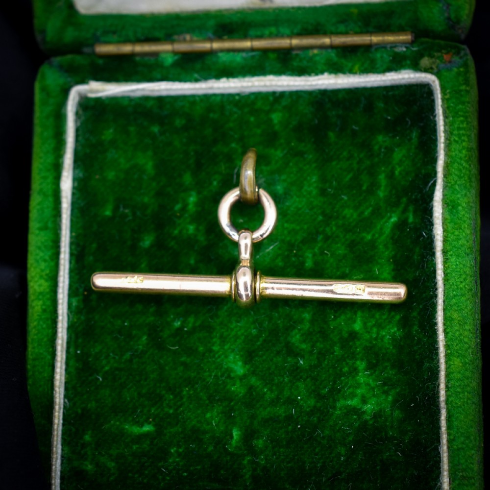 An antique 15ct yellow gold T-bar pendant featuring a smooth crossbar, central jump rings, and stamped British hallmarks. View II