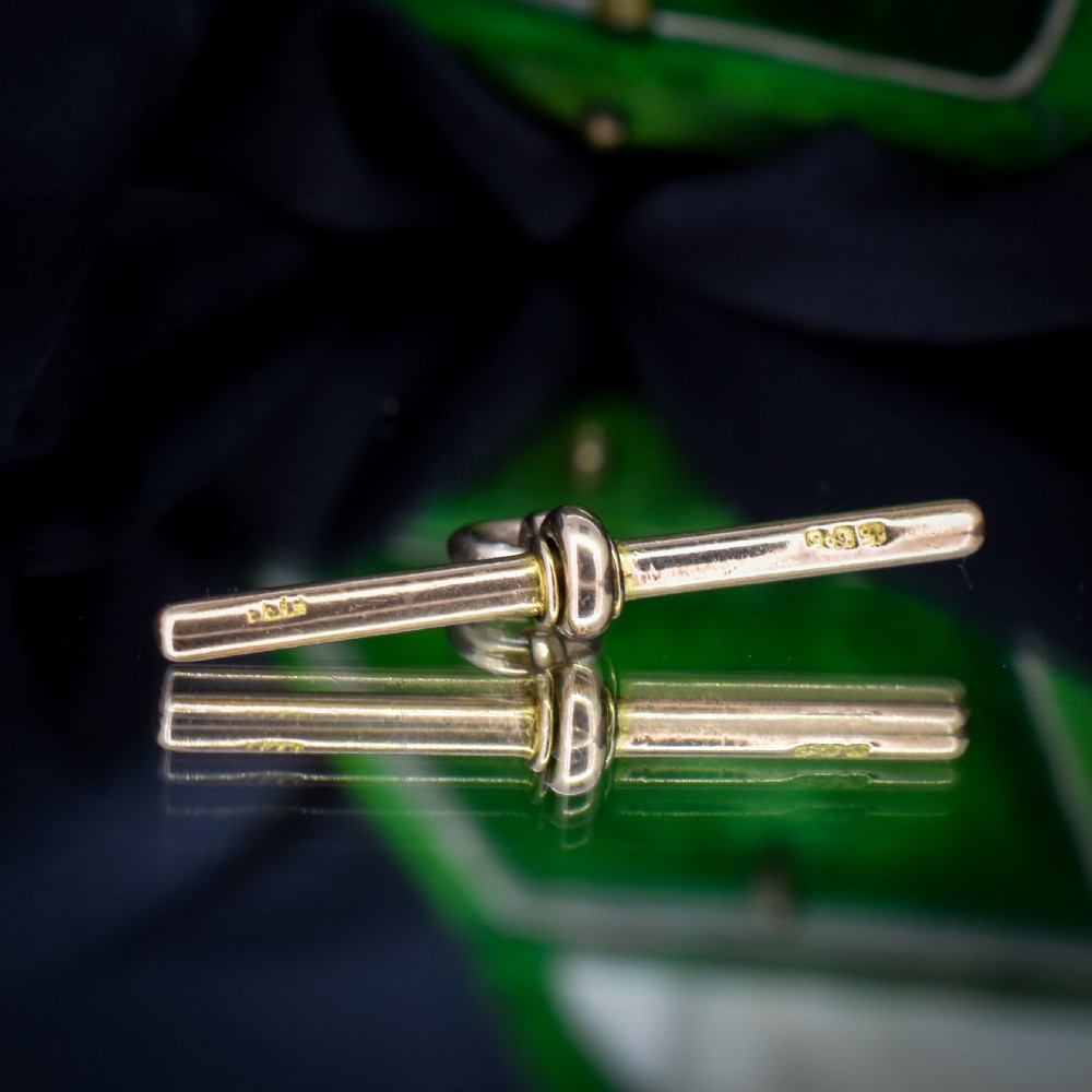 An antique 15ct yellow gold T-bar pendant featuring a smooth crossbar, central jump rings, and stamped British hallmarks. View VI