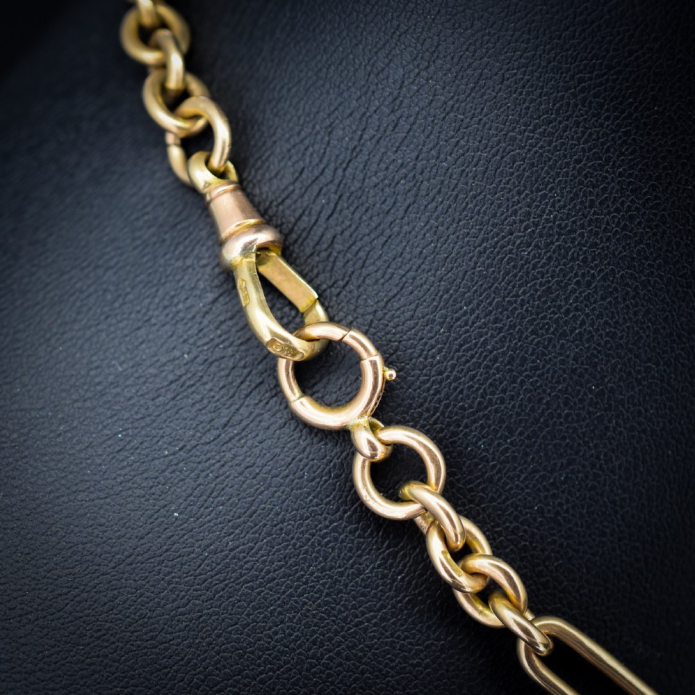 A 9ct yellow gold Art Deco Albert watch chain featuring alternating elongated trombone links, a swivel clasp, and a T-bar. View VI
