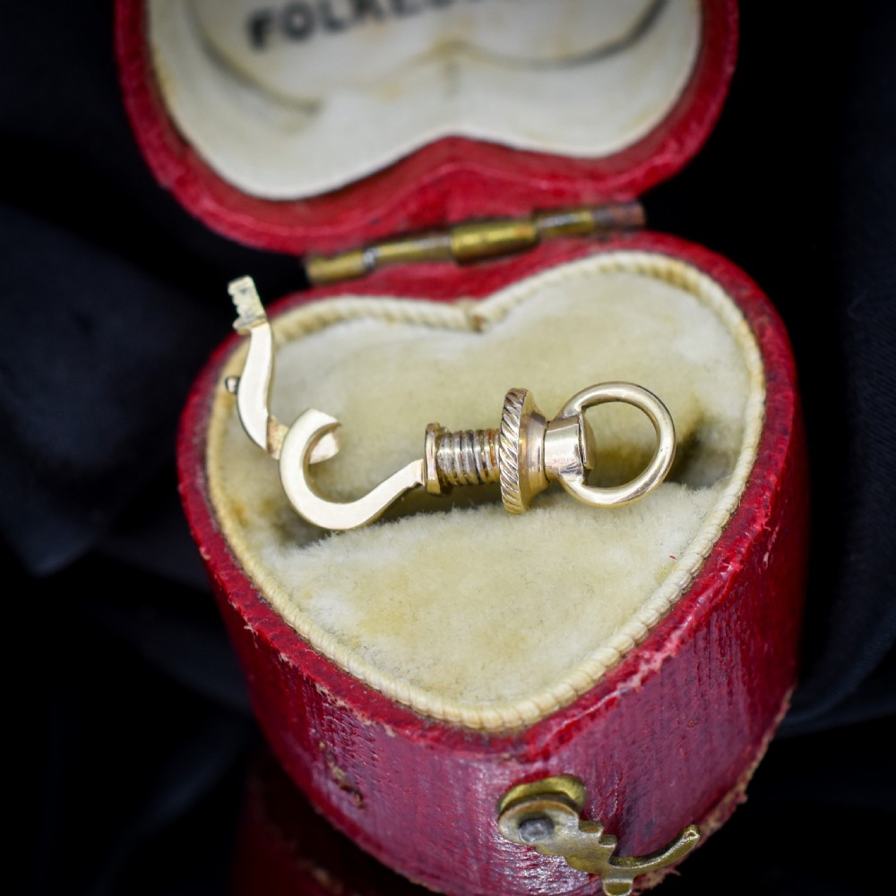 An antique 12ct yellow gold dog clip fastener with a textured screw collar mechanism and top swivel ring. View IV