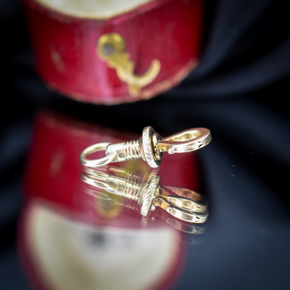 An antique 12ct yellow gold dog clip fastener with a textured screw collar mechanism and top swivel ring. View V