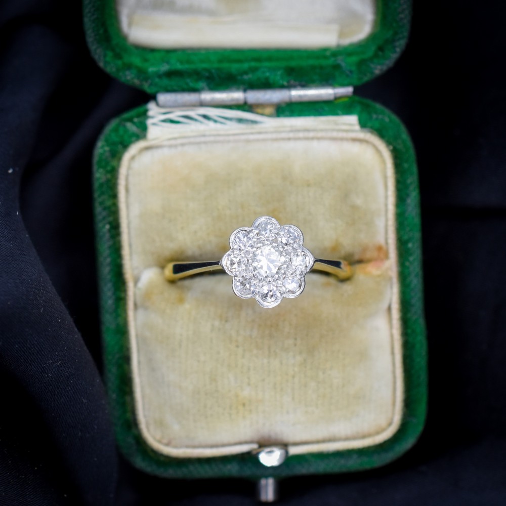 An antique diamond cluster ring arranged in a floral daisy pattern, set in platinum with an 18ct yellow gold band. View III