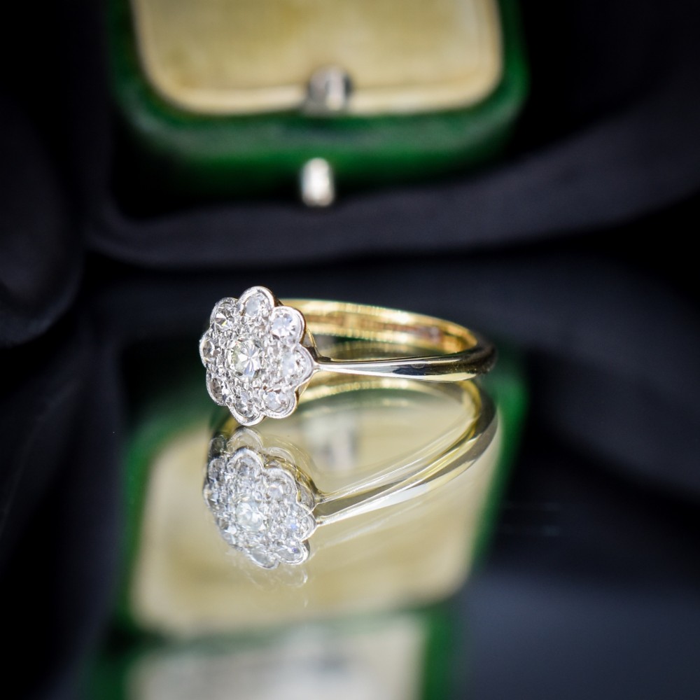An antique diamond cluster ring arranged in a floral daisy pattern, set in platinum with an 18ct yellow gold band. View VII