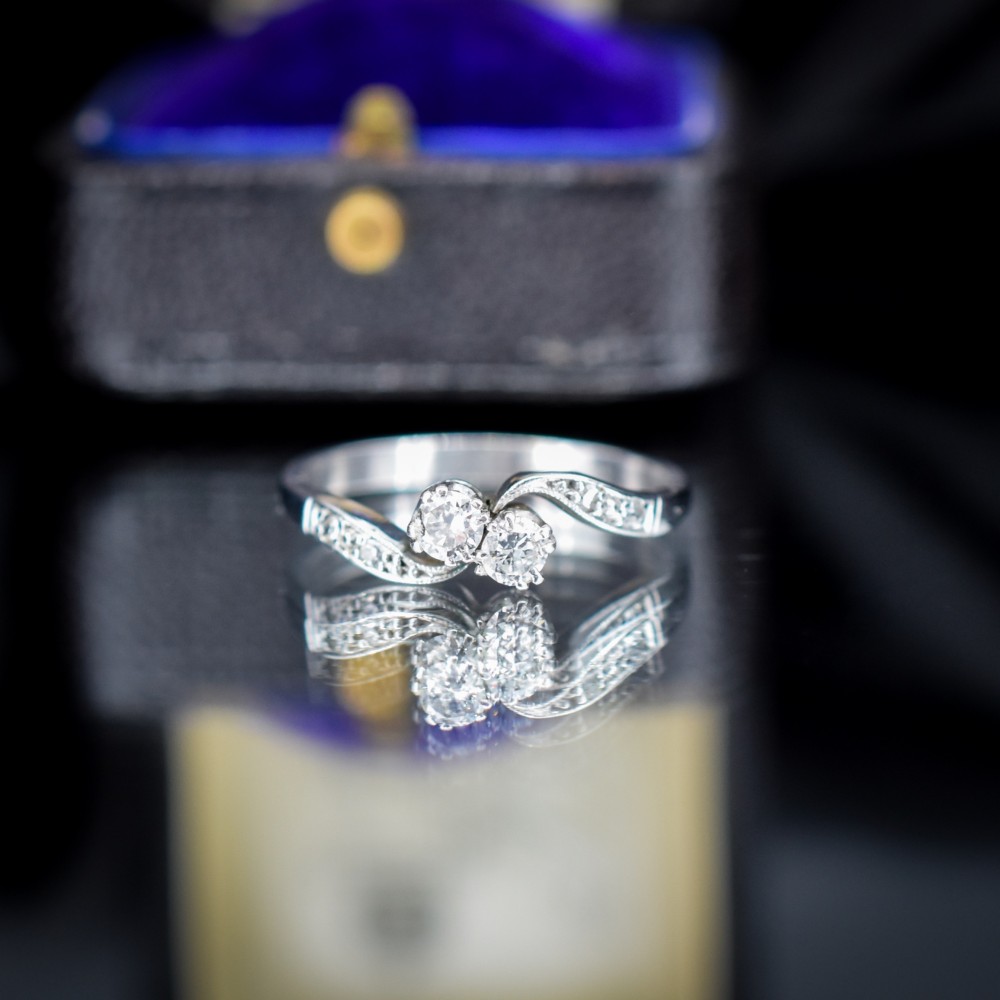An antique 18ct white gold Toi et Moi ring featuring two central round diamonds set in a diagonal twist arrangement with diamond-set shoulders. View III