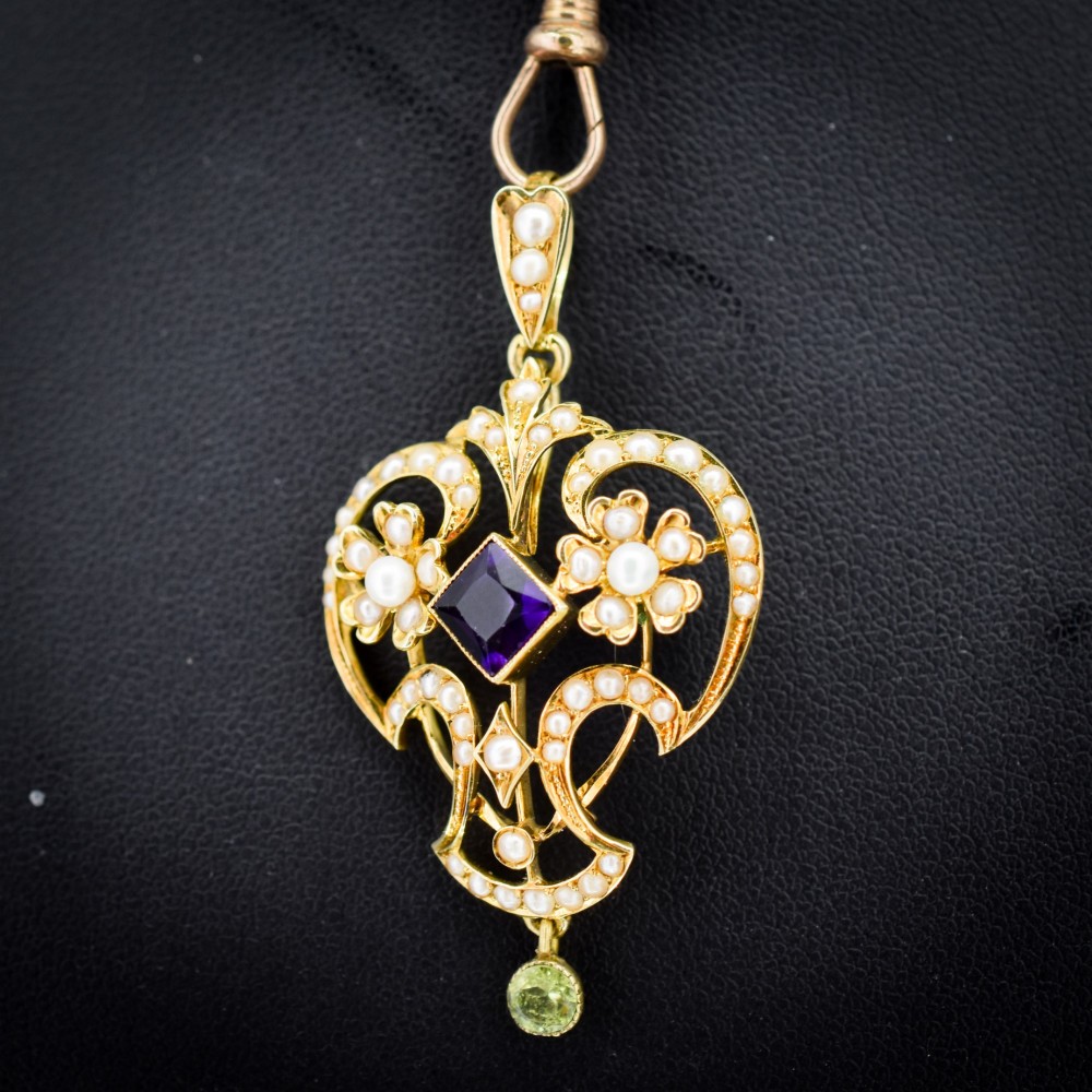 An ornate openwork 15ct gold Edwardian pendant decorated with seed pearls, a square central amethyst, and a hanging round peridot drop. View III