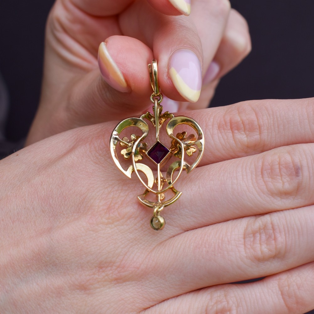 An ornate openwork 15ct gold Edwardian pendant decorated with seed pearls, a square central amethyst, and a hanging round peridot drop. View VIII