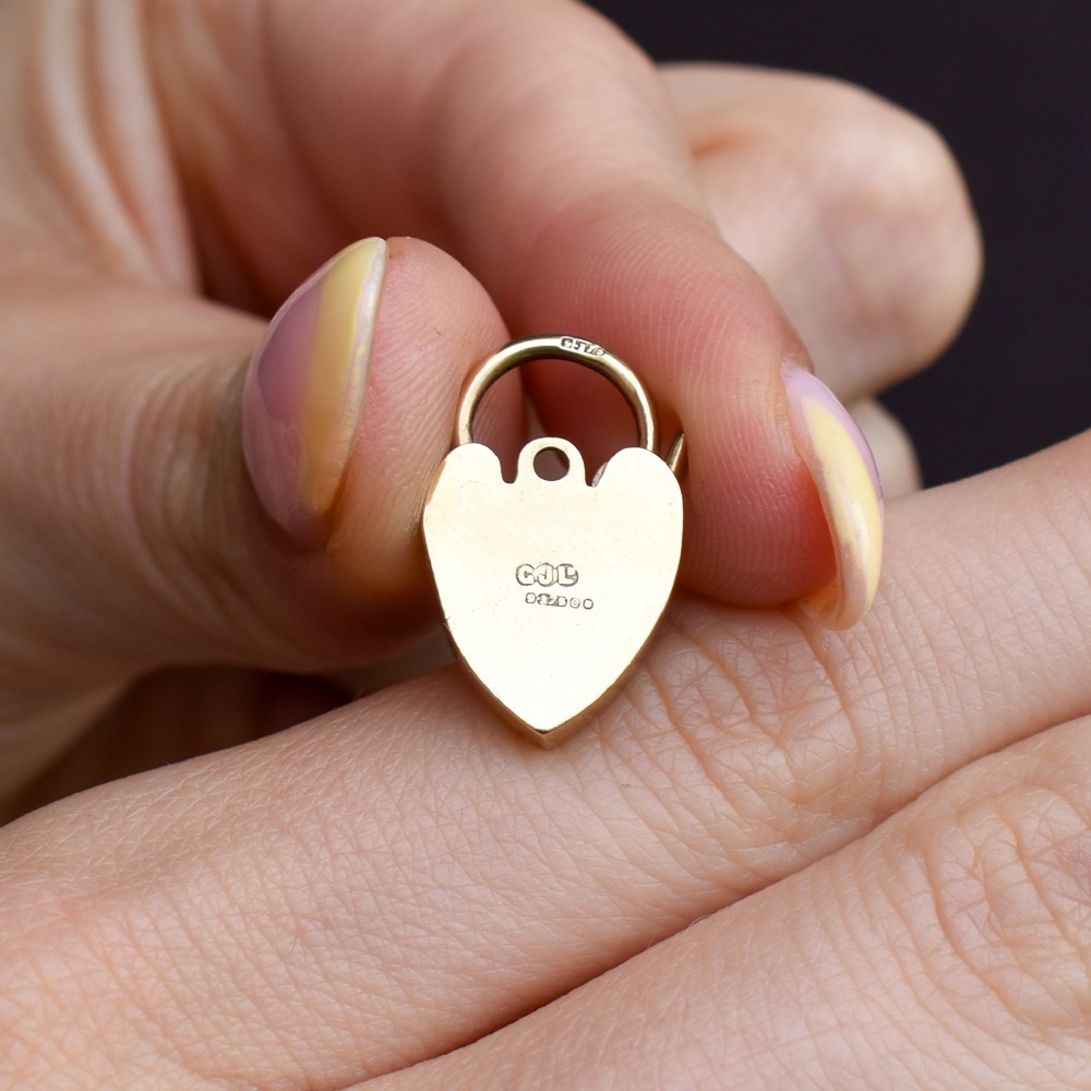 A 9ct yellow gold heart-shaped padlock charm featuring hand-engraved scrollwork and a keyhole detail. View VIII