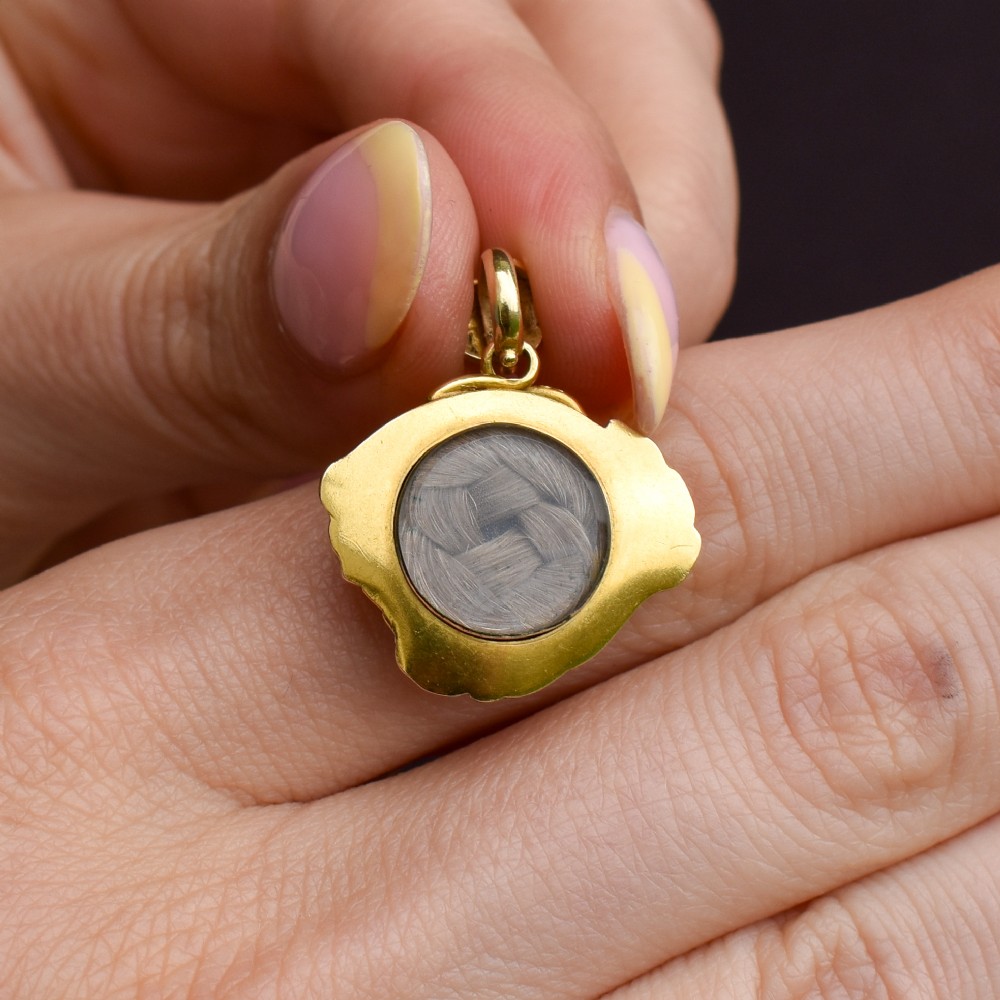 An antique 18ct yellow gold pendant featuring swirling scrollwork inlaid with vibrant turquoise blue enamel. View VII