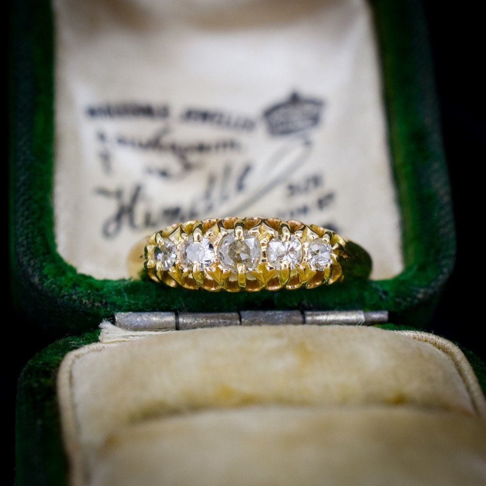 An 18ct yellow gold five-stone ring set with old cut diamonds in a carved scrollwork gallery. View II