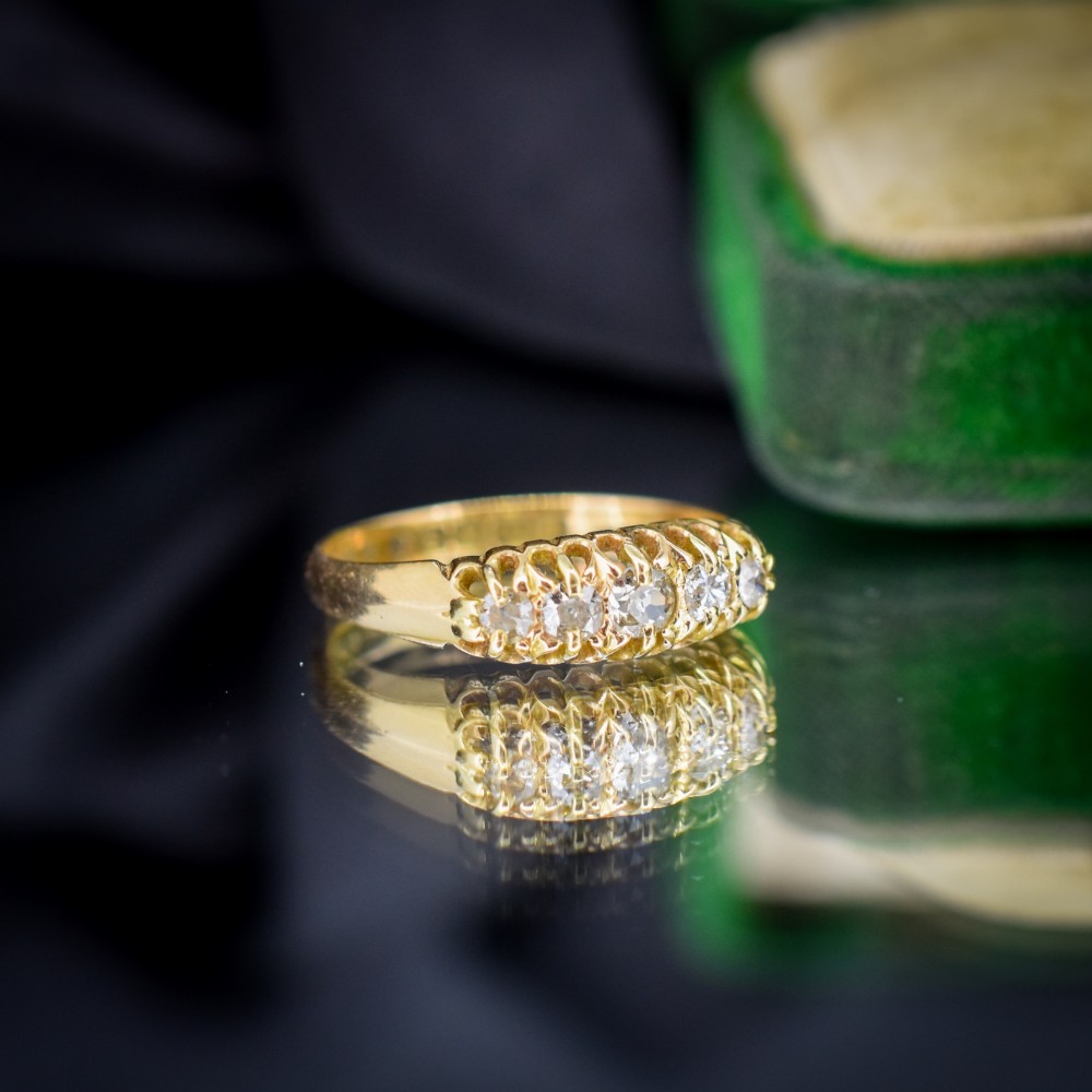 An 18ct yellow gold five-stone ring set with old cut diamonds in a carved scrollwork gallery. View III