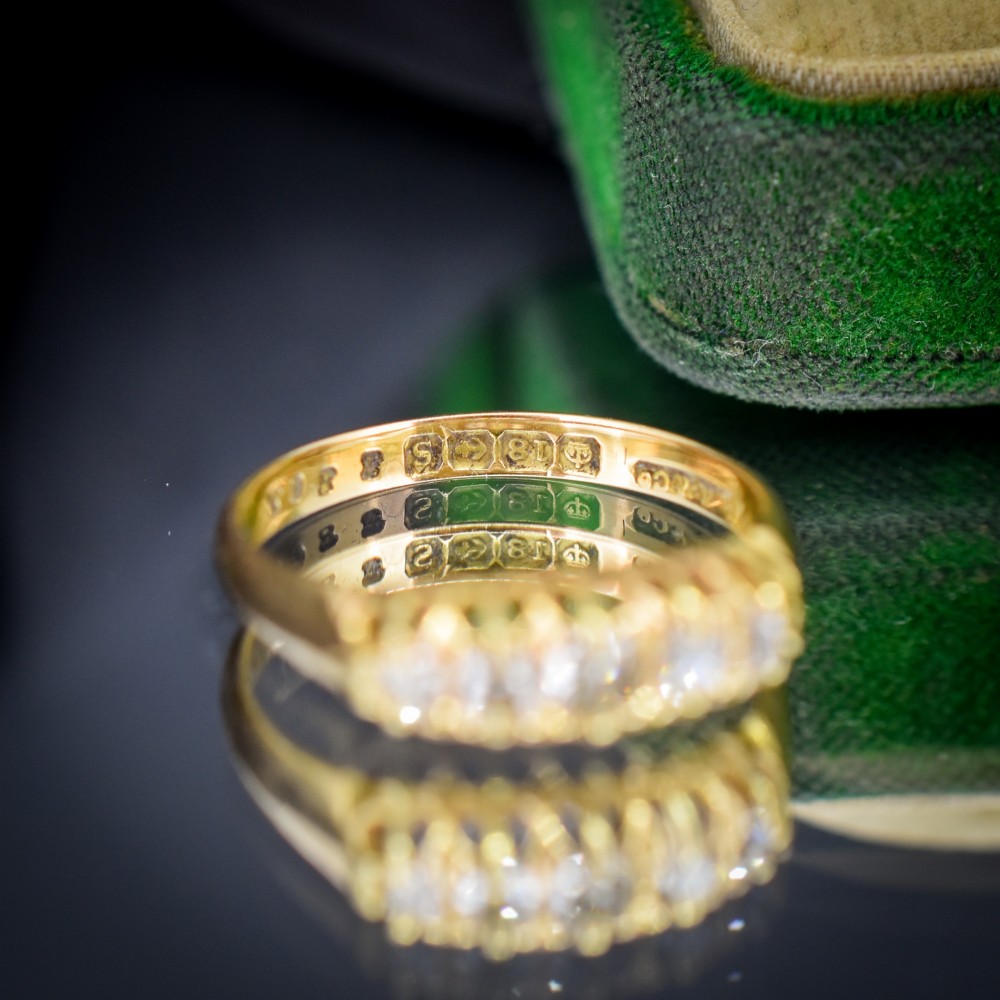 An 18ct yellow gold five-stone ring set with old cut diamonds in a carved scrollwork gallery. View V