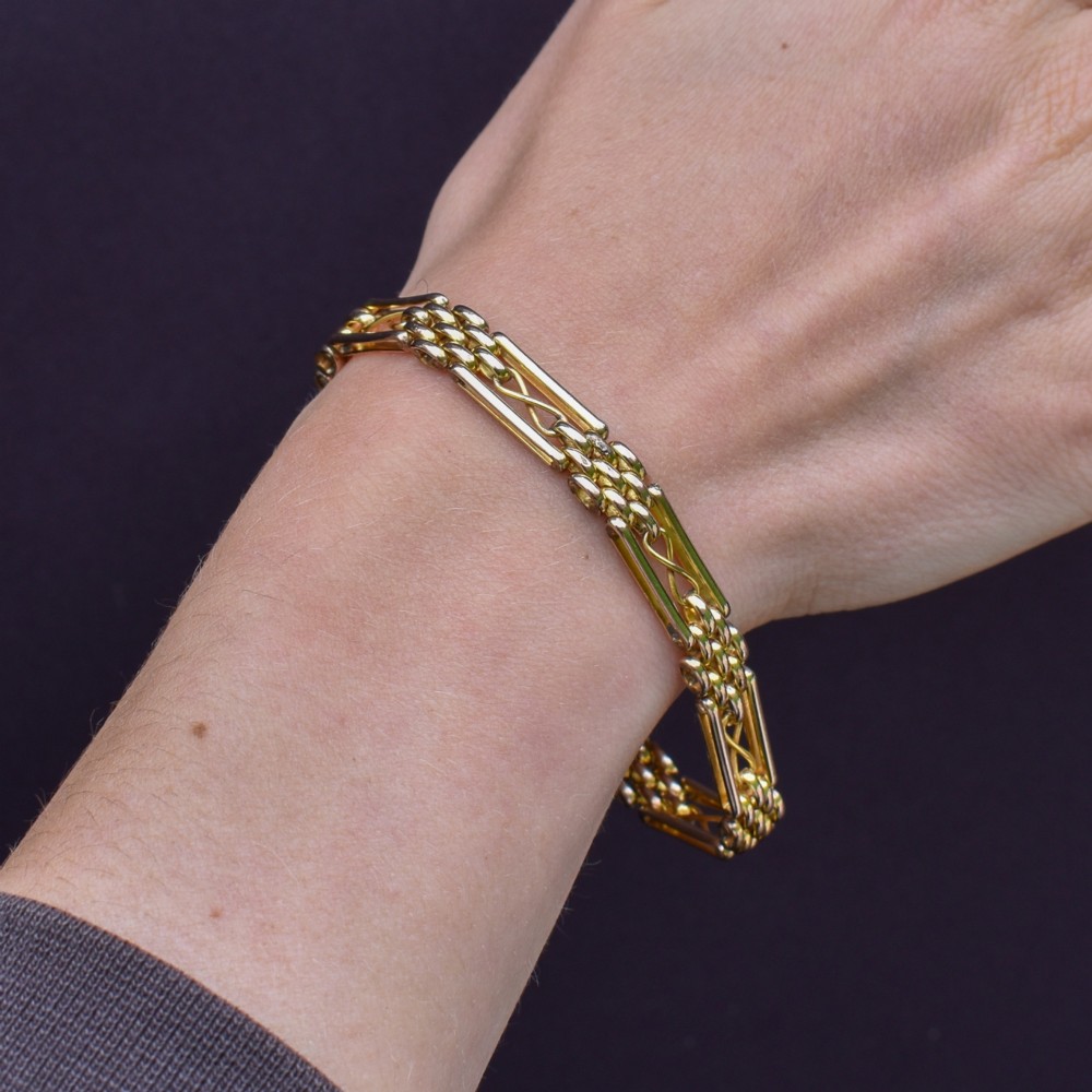 An antique rolled gold gate link bracelet featuring multi-row interlocking bars and a central heart-shaped padlock clasp with a safety chain. View XIII