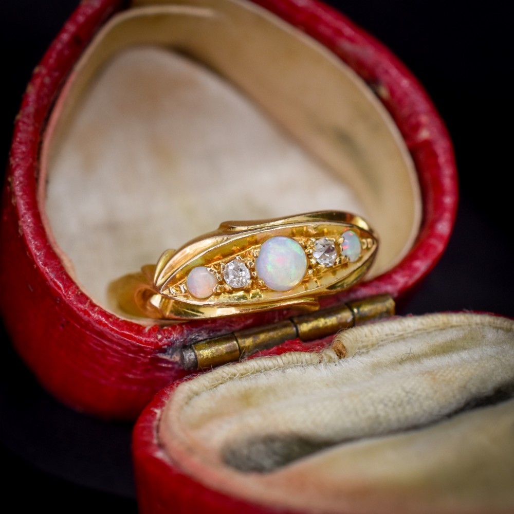 An antique 18ct yellow gold boat setting ring featuring three cabochon opals and two small diamonds. View II