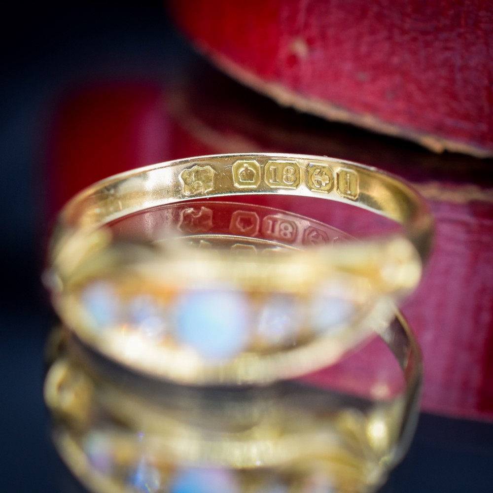 An antique 18ct yellow gold boat setting ring featuring three cabochon opals and two small diamonds. View VII