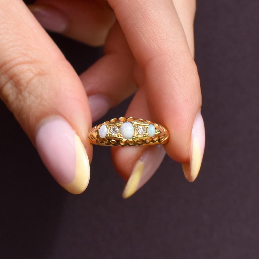 An antique 18ct yellow gold boat setting ring featuring three cabochon opals and two small diamonds. View VIII