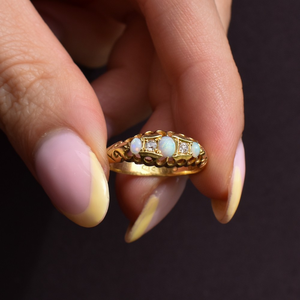 An antique 18ct yellow gold boat setting ring featuring three cabochon opals and two small diamonds. View IX