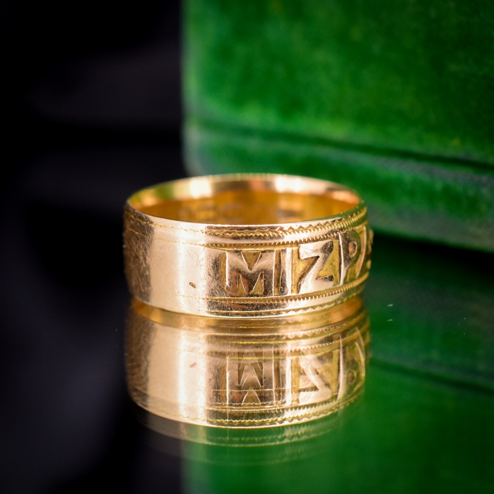 An antique 18ct yellow gold wide band ring featuring the word MIZPAH in raised relief lettering bordered by beaded detailing. View V