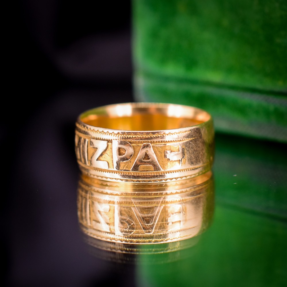 An antique 18ct yellow gold wide band ring featuring the word MIZPAH in raised relief lettering bordered by beaded detailing. View VIII