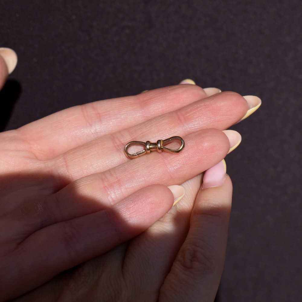 A double-ended 9ct yellow gold dog clip clasp featuring a polished surface and central moulded collar. View IX