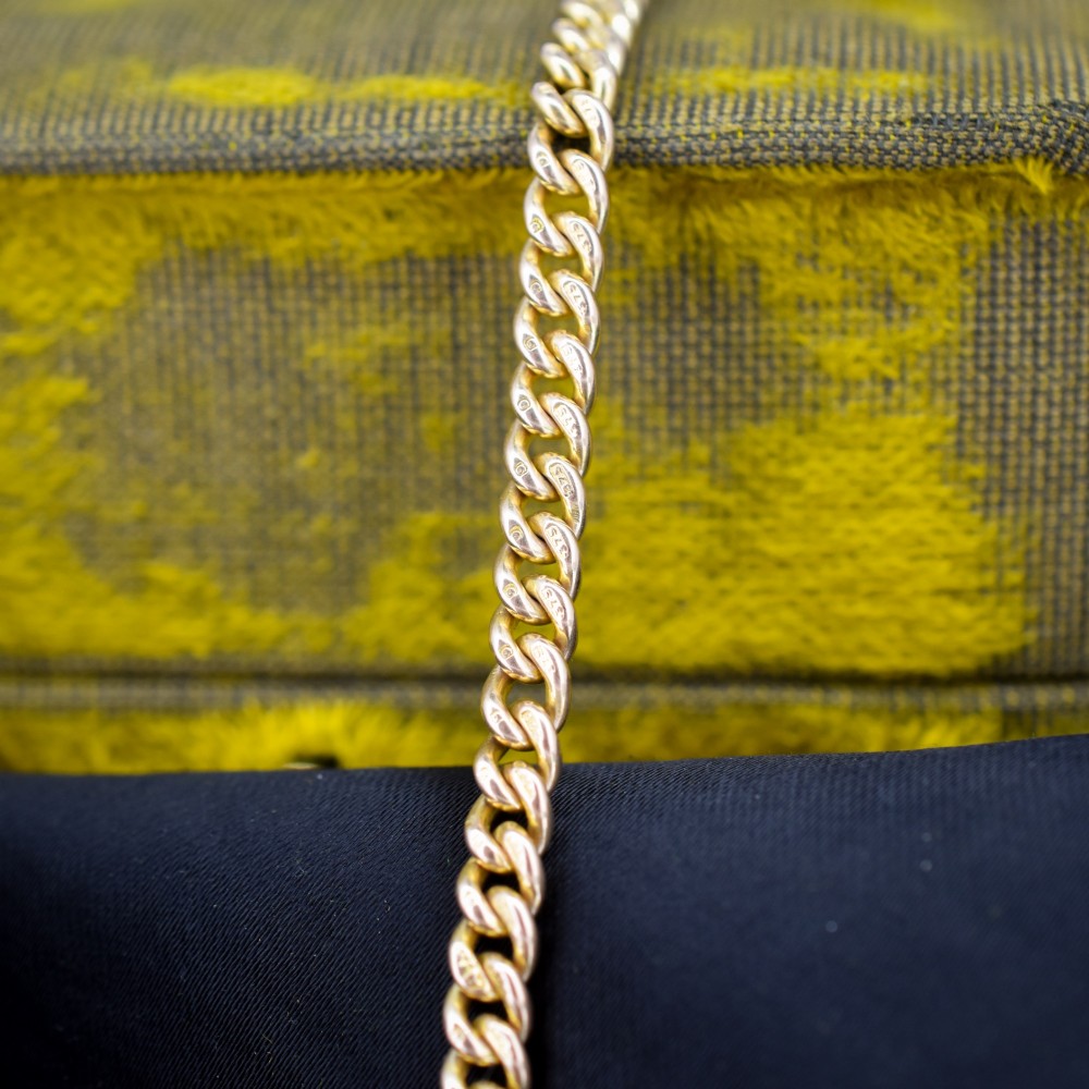 An antique 9ct yellow gold curb link chain bracelet fitted with a dog clip swivel clasp. View V
