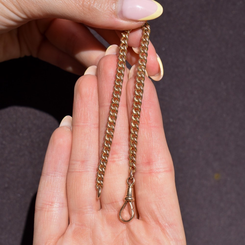 An antique 9ct yellow gold curb link chain bracelet fitted with a dog clip swivel clasp. View VII