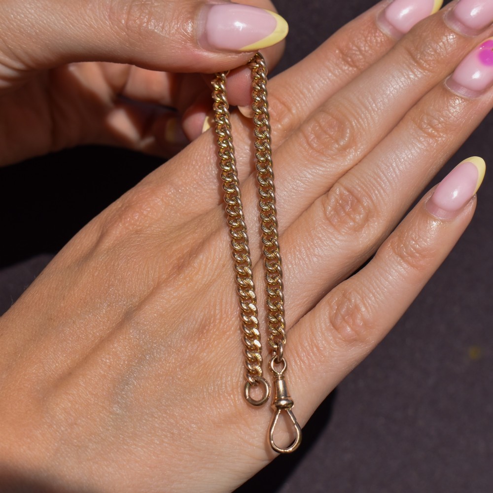 An antique 9ct yellow gold curb link chain bracelet fitted with a dog clip swivel clasp. View VIII