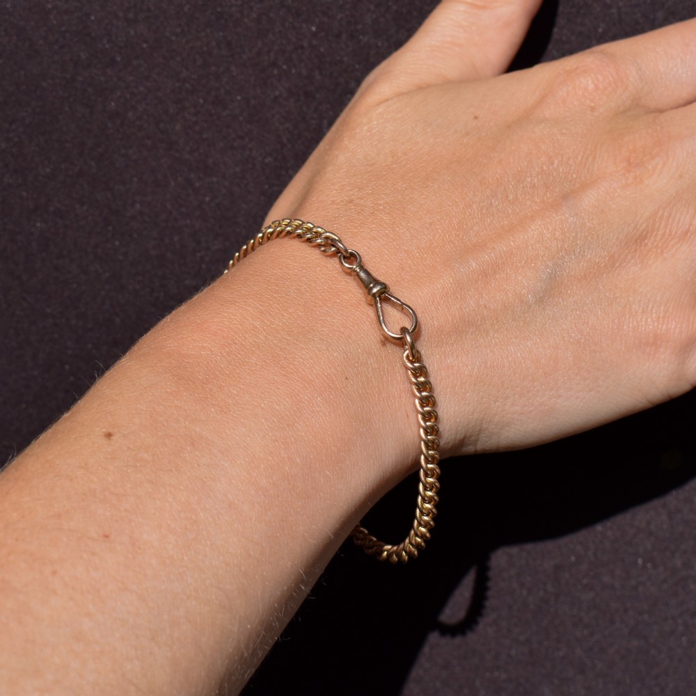 An antique 9ct yellow gold curb link chain bracelet fitted with a dog clip swivel clasp. View IX